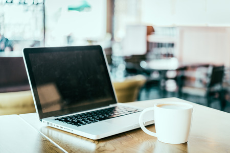 Coffee cup , laptop in coffee shop - vintage effect style picturesの写真素材