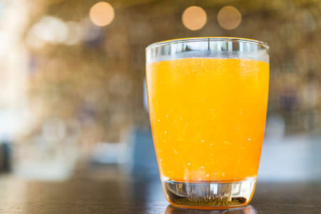 Orange juice glass on bokeh backgroundの写真素材