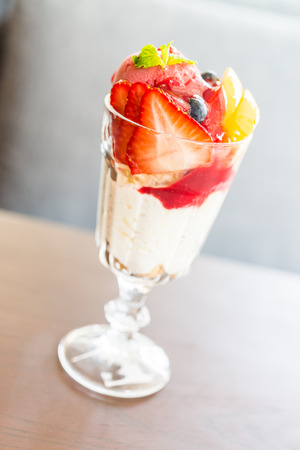 Parfait yogurt fruit in glass on wooden tableの写真素材