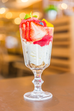 Parfait yogurt fruit in glass on wooden tableの写真素材