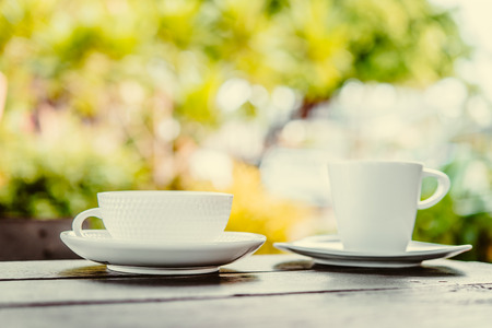 White coffee cup on wooden tables and outdoor garden background - Processing color effect style picturesの写真素材
