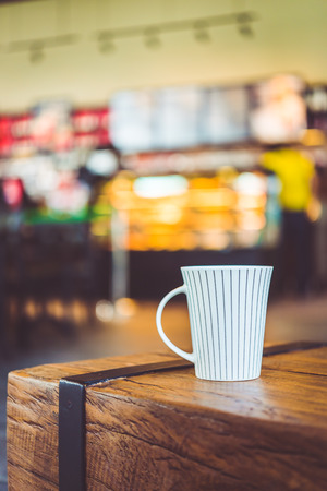 Hot latte Coffee cup on wooden table in coffee shop - vintage effect style picturesの写真素材