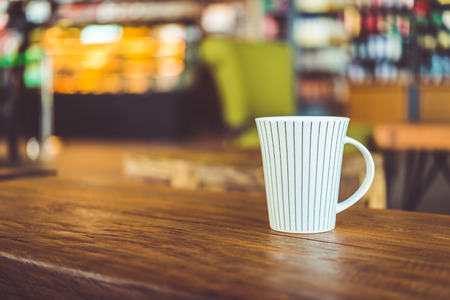 Hot latte Coffee cup on wooden table in coffee shop - vintage effect style picturesの写真素材
