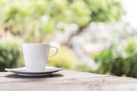 White coffee cup on wooden tables and outdoor garden background - Processing color effect style picturesの写真素材