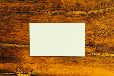 White card on wooden background - vintage effect style picturesの写真素材
