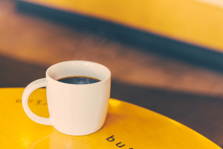 Black Coffee mug on wooden table in coffee shop - Vintage retro effect style picturesの写真素材