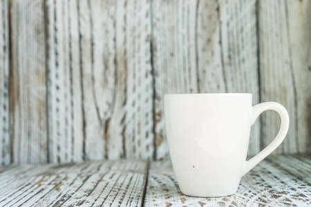 white coffee mug on wood