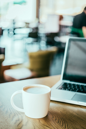 Coffee cup , laptop in coffee shop - vintage effect style picturesの写真素材