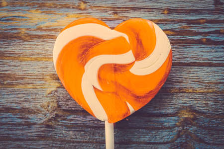 Heart lollipop candy on wood background - Vintage effect style picturesの写真素材