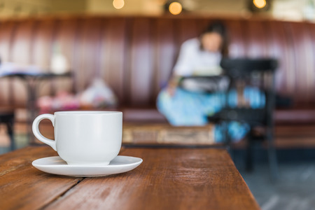 White coffee cup on wooden table in coffee shopの写真素材