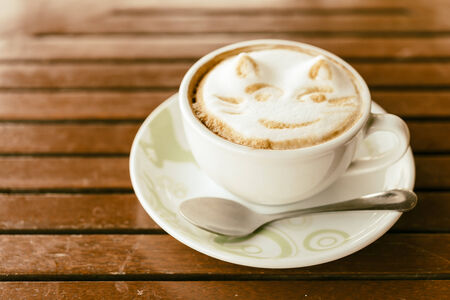 Latte coffee mug on wooden table - vintage effect style picturesの写真素材
