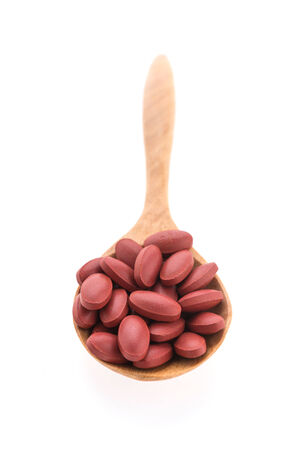 Pill on spoon isolated on white backgroundの写真素材