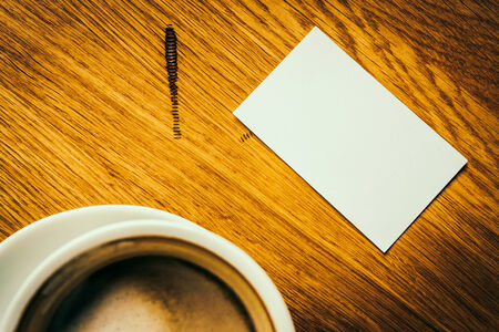 White card and coffee cup on wooden background - vintage effect style pictures