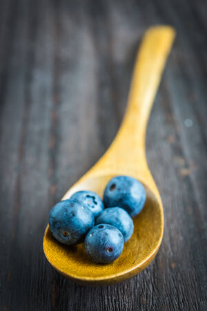 Blueberry spoon on wooden background - vintage effect style picturesの写真素材