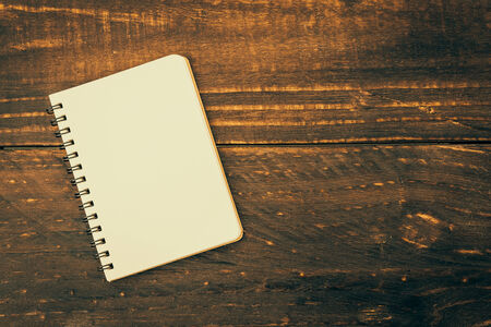 Note book on wooden background - Vintage effect style picturesの写真素材