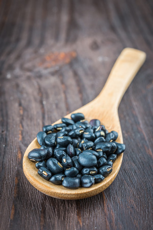 Black beans on wooden background - vintage effect style picturesの写真素材