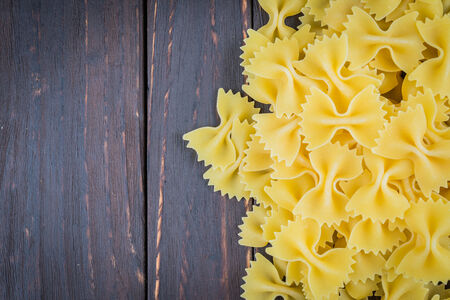 Raw pasta on wooden background - process old dark style picture