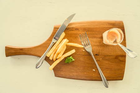 Dirty wood plate after eating sandwich and french fries - vintage effect style picturesの写真素材
