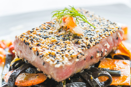 Grilled Tuna fish meat steak with black spaghetti - soft focus pointの写真素材