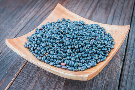 Black beans on wooden background - vintage effect style picturesの写真素材