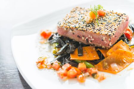 Grilled Tuna fish meat steak with black spaghetti - soft focus pointの写真素材