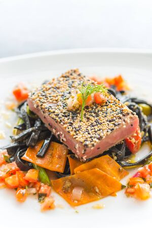 Grilled Tuna fish meat steak with black spaghetti - soft focus pointの写真素材