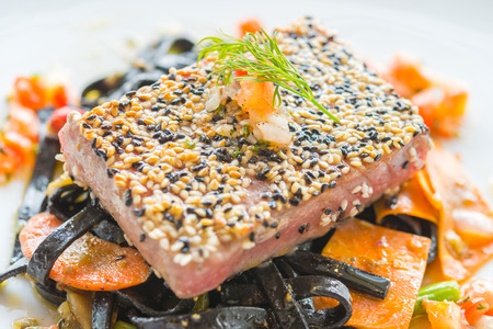 Grilled Tuna fish meat steak with black spaghettiの写真素材
