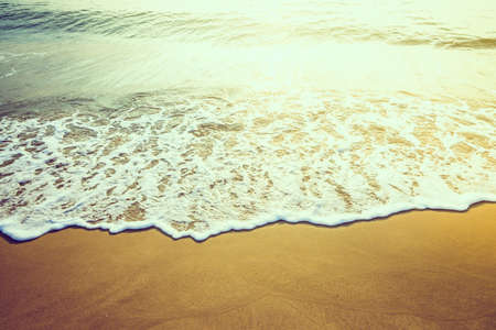 Wave sea water on the beach - vintage effect style and sun flare filter processing style picturesの写真素材