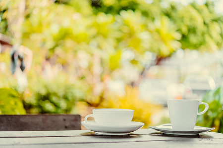 White coffee cup on wooden tables and outdoor garden background - Processing color effect style picturesの写真素材