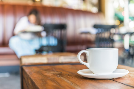 White coffee cup on wooden table in coffee shopの写真素材