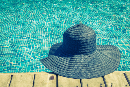 Woman hat in swimming pool - vintage filterの写真素材