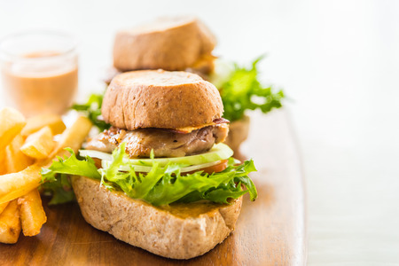 Chicken Sandwich and french fries on wood trayの写真素材