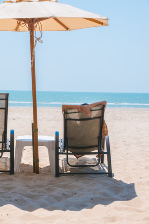 Young woman on bed deck tropical beach with blue skyの写真素材