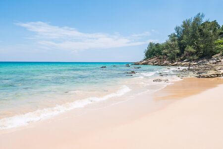 Tropical summer beach and sea wave on blue sky backgroundの写真素材