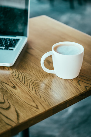 Coffee cup , laptop in coffee shop - vintage effect style picturesの写真素材
