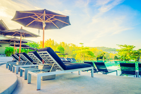 Umbrella pool chair - vintage filter and sunflare effectの写真素材