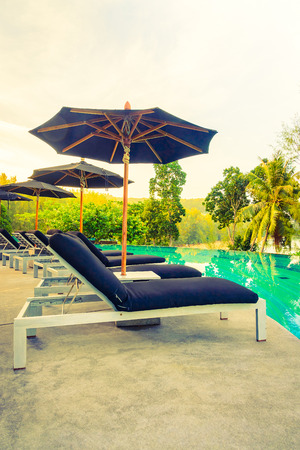 Umbrella pool chair - vintage filter and sunflare effectの写真素材