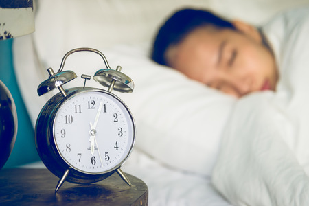 Clock in bedroom with woman sleeping Clock in bedroom with woman sleeping
