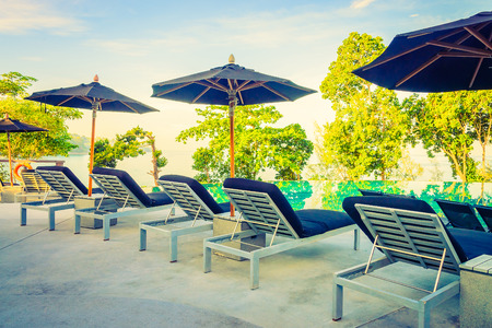 Umbrella pool chair - vintage filter and sunflare effectの写真素材