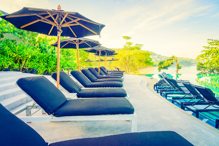 Umbrella pool chair - vintage filter and sunflare effectの写真素材