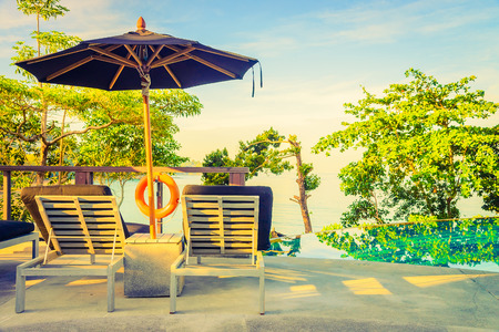 Umbrella pool chair - vintage filter and sunflare effectの写真素材