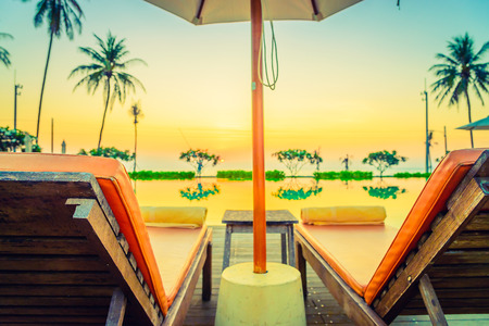 Twilight time Sunset umbrella deck chair pool - vintage filter effectの写真素材