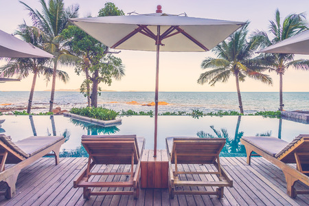 Resort pool with umbrella and chair - vintage filter effectの写真素材