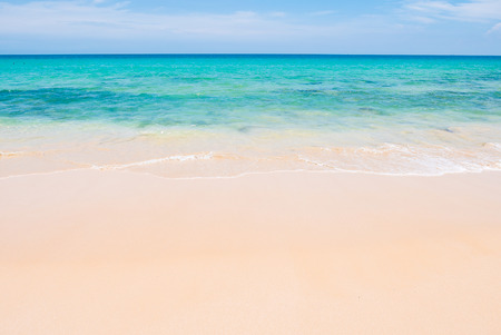 Tropical summer beach and sea wave on blue sky backgroundの写真素材