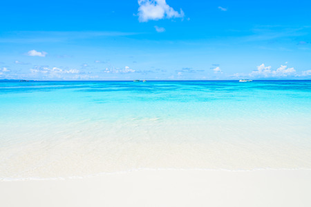 Beautiful tropical beach sand and sea with blue sky backgroundの写真素材