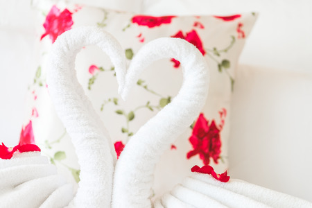 Towel swans and rose flower on bedroom for honeymoon couple - selective focus pointの写真素材