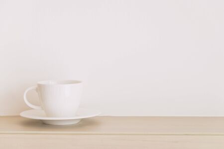 White coffee cup on white wall with copy space - soft vintage filterの写真素材