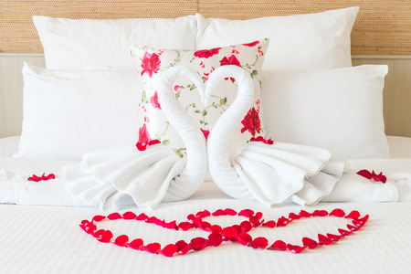 Towel swans and rose flower on bedroom for honeymoon couple - selective focus pointの写真素材