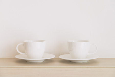 White coffee cup on white wall with copy space - soft vintage filterの写真素材