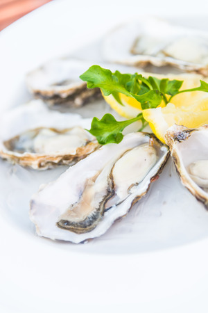 Selective focus point on fresh oysters shell with lemonの写真素材